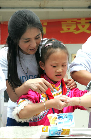 在北川县擂鼓镇中心小学，杨采妮帮助小学生掌握正确的洗手方法。