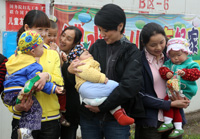 在安县沸水镇儿童友好家园，陈芷菁（居中）抱着一个孩子和园内的家长们交流。