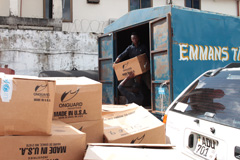 在塞拉利昂的邦巴利区，一名工作人员正在把个人防护用品从联合国儿童基金会当地办公室的货车上搬运下来。