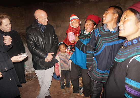 2015年1月15日，在四川省凉山彝族自治州昭觉县跳坝村的一户村民家里，联合国儿童基金会驻东亚及太平洋地区主任丹尼尔·图尔（Daniel Toole）与村民交谈。