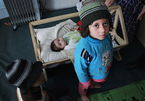 在土耳其，联合国儿童基金会为叙利亚难民儿童发放御寒冬衣。