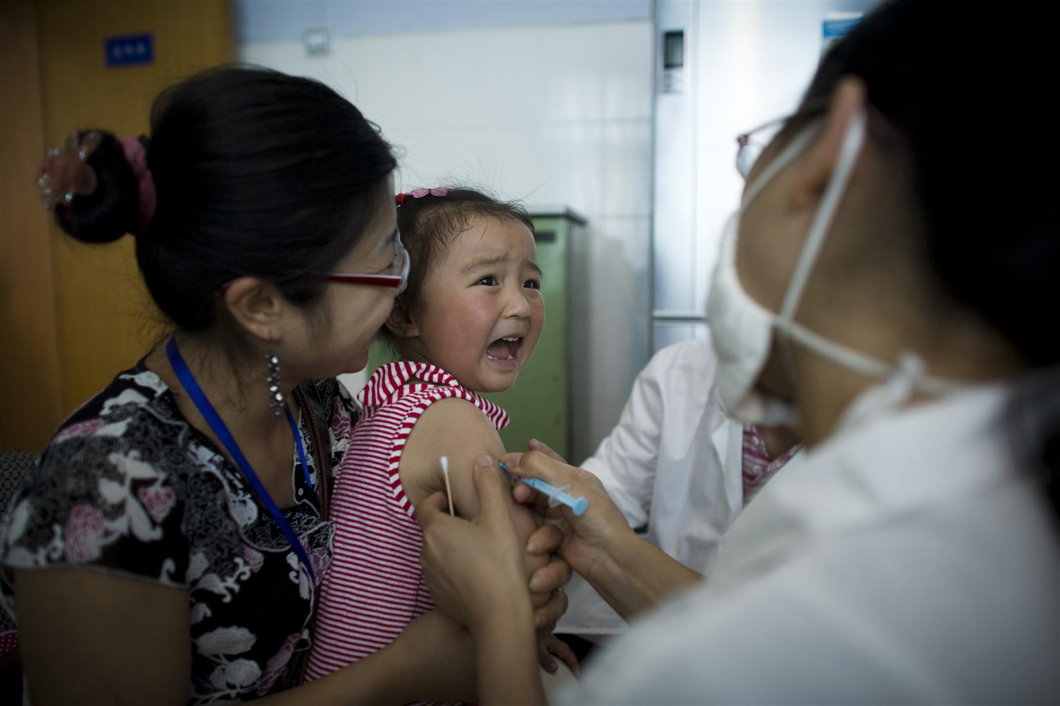 在四川省成都市，一名女孩在医院接受接种。