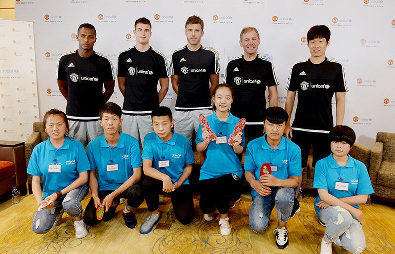 在联合国儿童基金会与曼联在上海联合举办的活动上，青少年向曼联传奇球员与现役球员送上富有传统特色的鞋垫。
