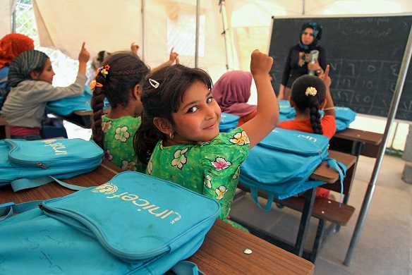 On 16 June a student raises her hand to answer a question from her teacher Hiba Ahmed in a tent classroom at the Al-Takya Al-Kaznazaniya school in Al-Takya Al-Kaznazaniya IDP camp, near Baghdad.