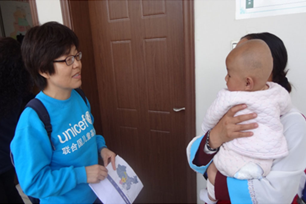 Dr Sufang Guo speaks to a mother with a young baby at Lijiang Maternal and Child Health Hospital, China