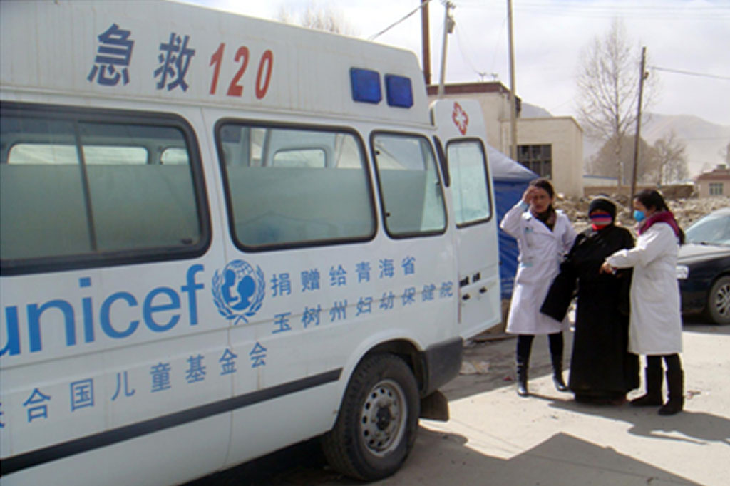 A pregnant womanwith complications is helped into an ambulancein Qinghai Province, China
